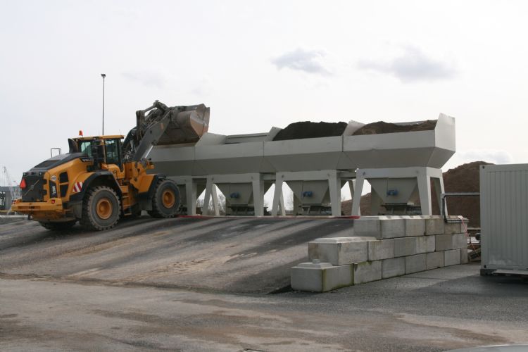 De menginstallatie in Dodewaard. De componenten worden op een transportband gedoseerd, in de mengtrommel op het juiste vochtpercentage gebracht en vervolgens met de transportband op de laadlocatie gestort.